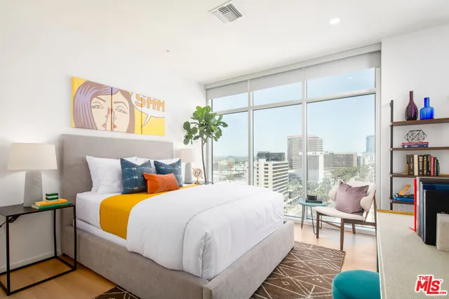 a bedroom with a bed and a large window