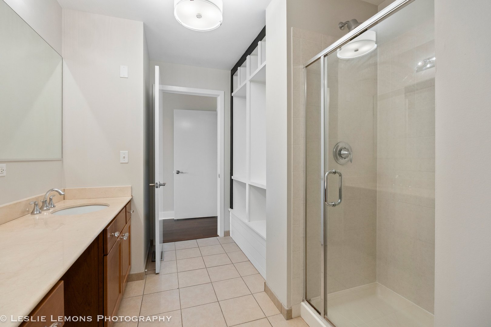 354 River Street, Unit 3407 Lemont, IL 60439 - Photo 12 of 15 a bathroom with a sink a mirror and a shower