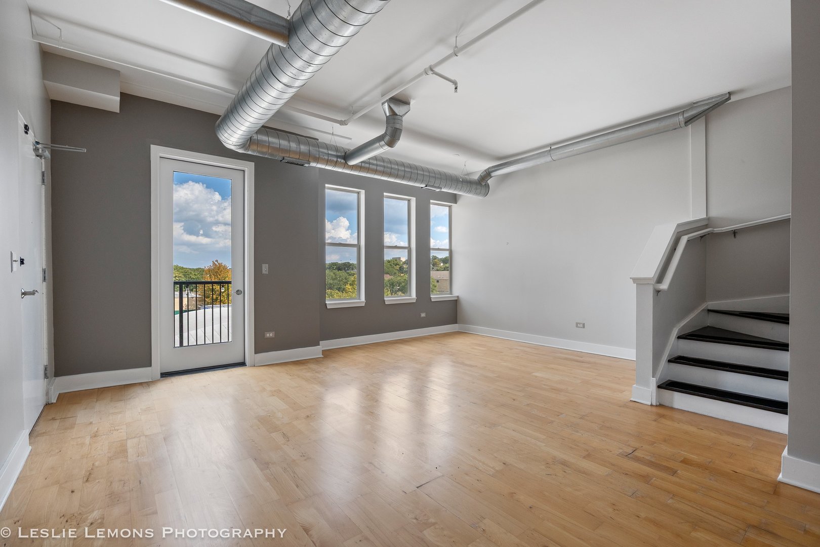 354 River Street, Unit 3407 Lemont, IL 60439 - Photo 4 of 15 a view of an empty room with wooden floor and windows