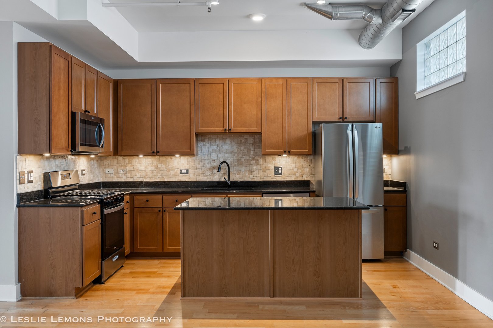354 River Street, Unit 3407 Lemont, IL 60439 - Photo 6 of 15 a kitchen with stainless steel appliances granite countertop a refrigerator a stove a sink and a microwave