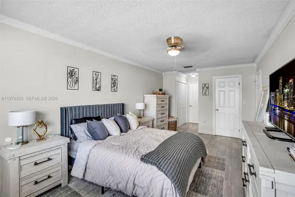 a bedroom with a bed and a flat tv screen on the dresser