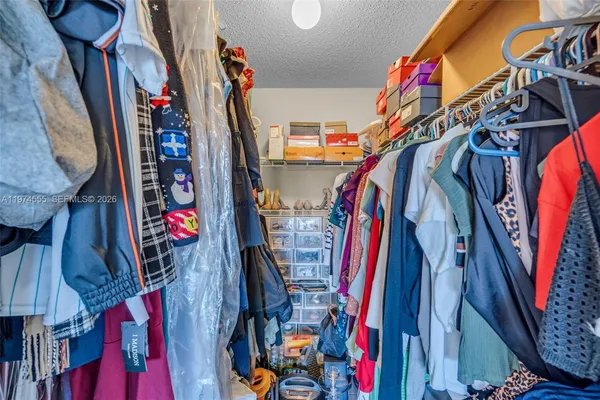 a view of walk in closet with clothes
