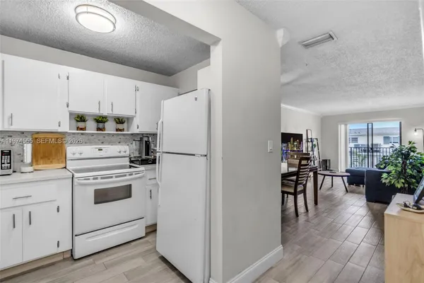 a kitchen with white cabinets and white appliances