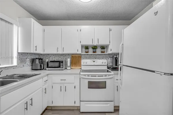 a kitchen with cabinets appliances and a sink