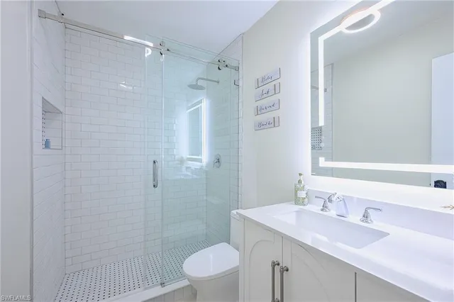 a bathroom with a sink a toilet and shower