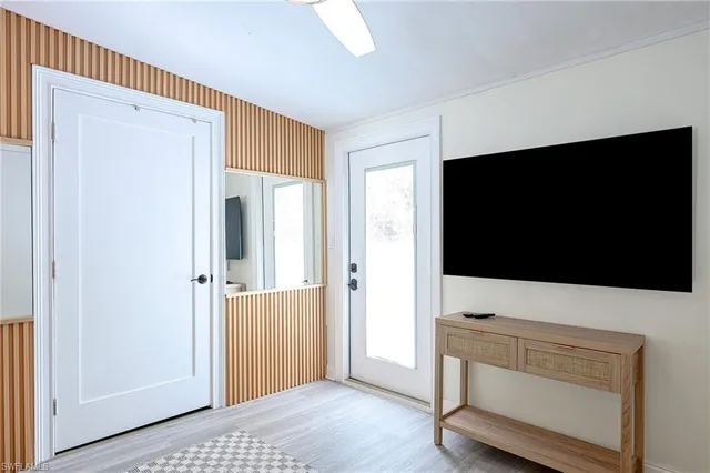 a living room with a flat screen tv and a refrigerator