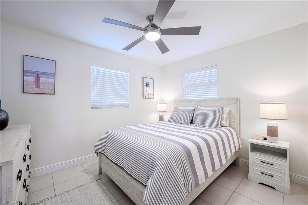 757 101st Avenue North Naples, FL 34108 - Photo 21 of 33 a bedroom with a bed and a chandelier