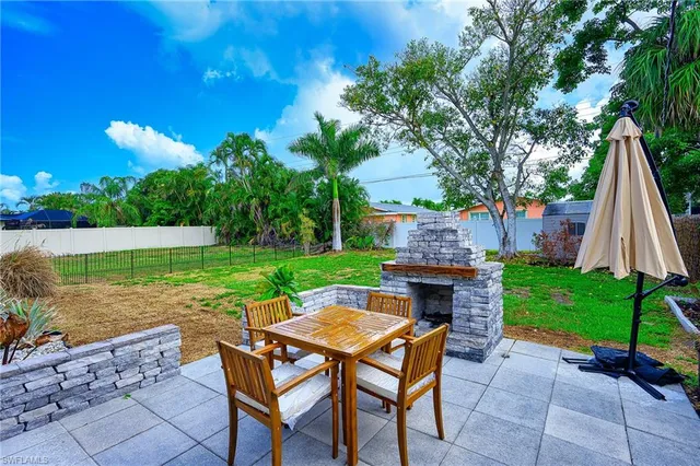 a backyard of a house with table and chairs