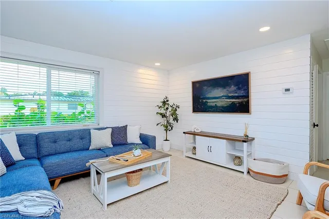 a living room with furniture a flat screen tv and a large window