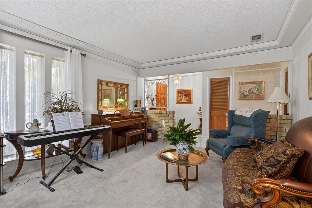6010 Hunters View Lane Dallas, TX 75232 - Photo 6 of 28 Carpeted interior space featuring a recessed ceiling, decorative crown molding, and large windows with vertical mullions