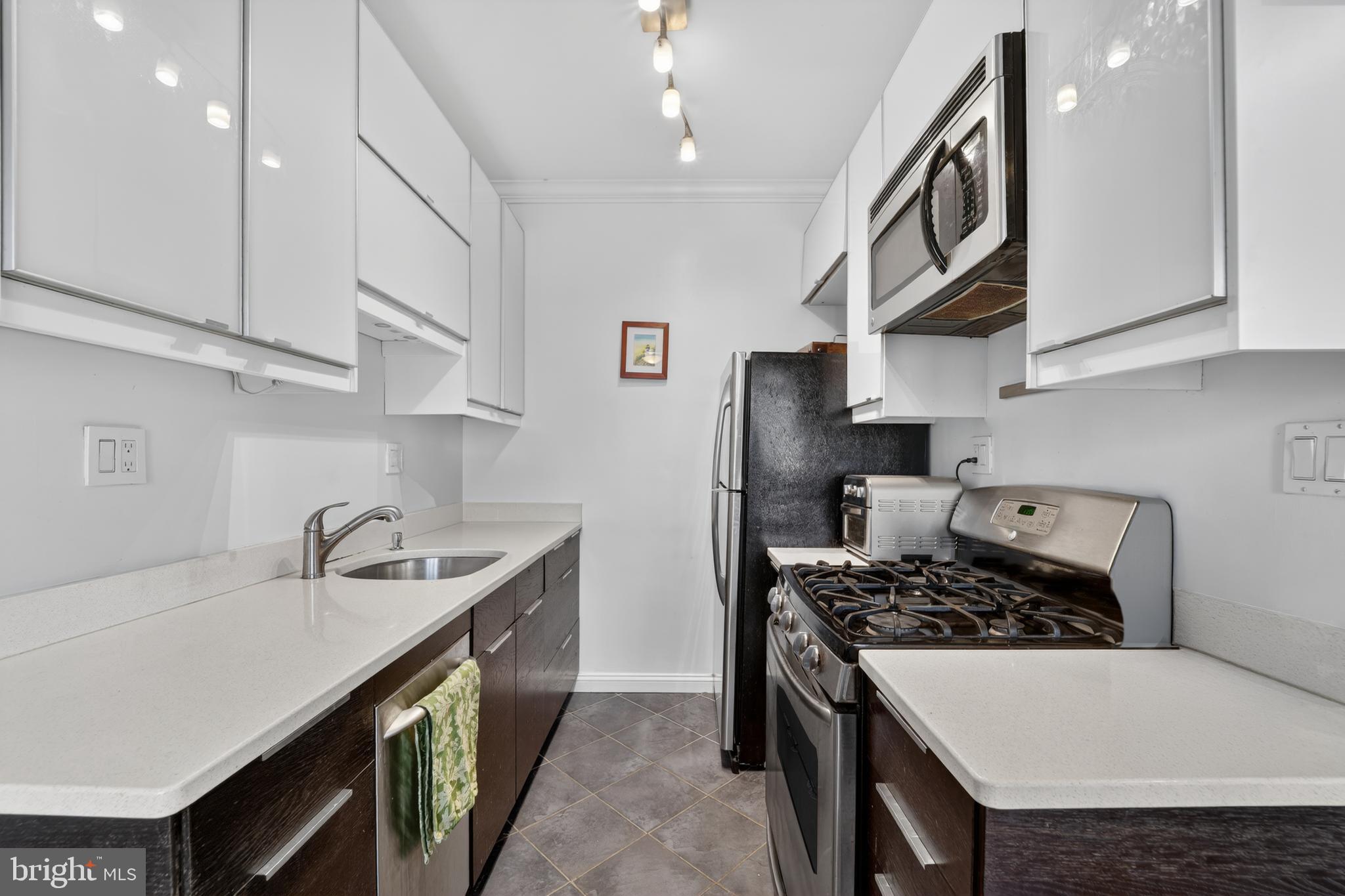 2325 42nd Street Northwest, Unit 104 Washington, DC 20007 - Photo 3 of 25 a kitchen with stainless steel appliances a sink a stove and cabinets