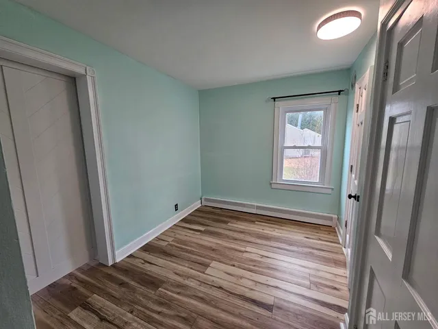 a view of a room with wooden floor and window