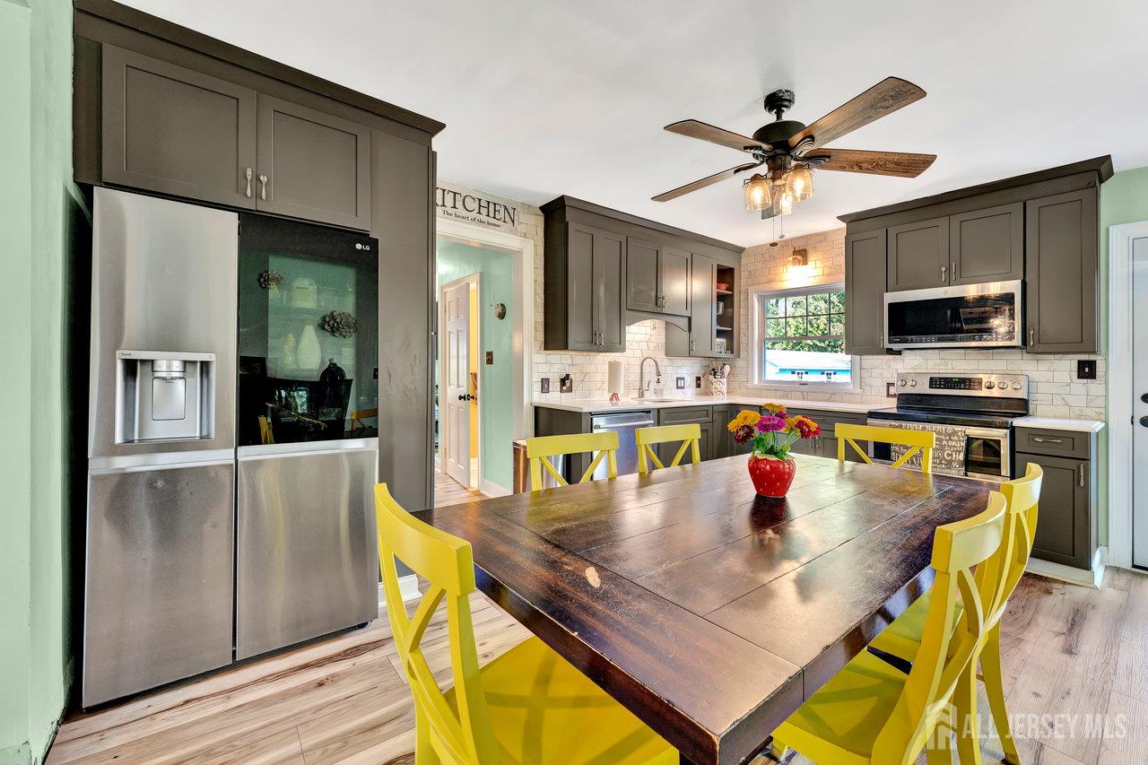 254 Friendship Road Monmouth Junction, NJ 08852 - Photo 18 of 42 a kitchen with a dining table chairs and refrigerator