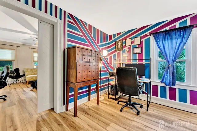 a view of a hallway with workspace and wooden floor