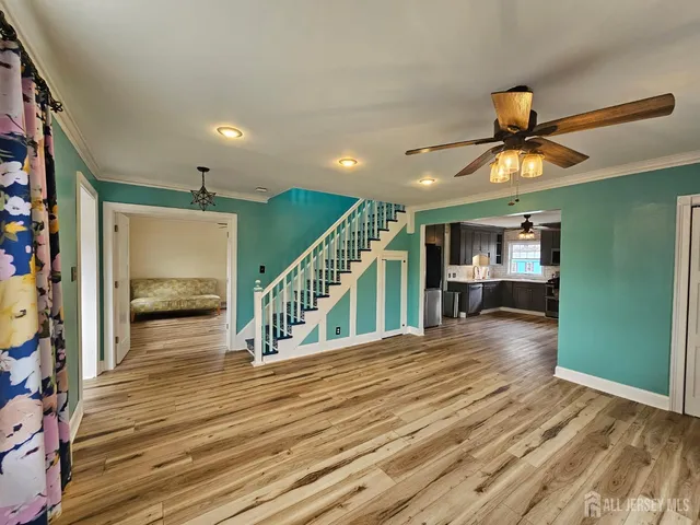 a view of a livingroom with a furniture stairs wooden floor and a chandelier
