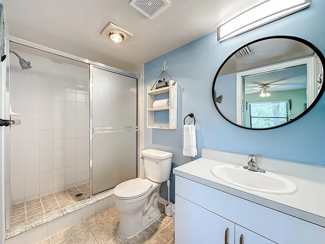 a bedroom with a bed a couch and a chandelier