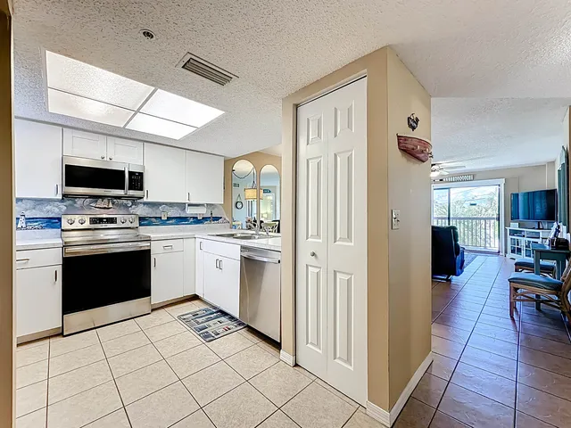 a kitchen with stainless steel appliances kitchen island granite countertop a refrigerator and a stove top oven