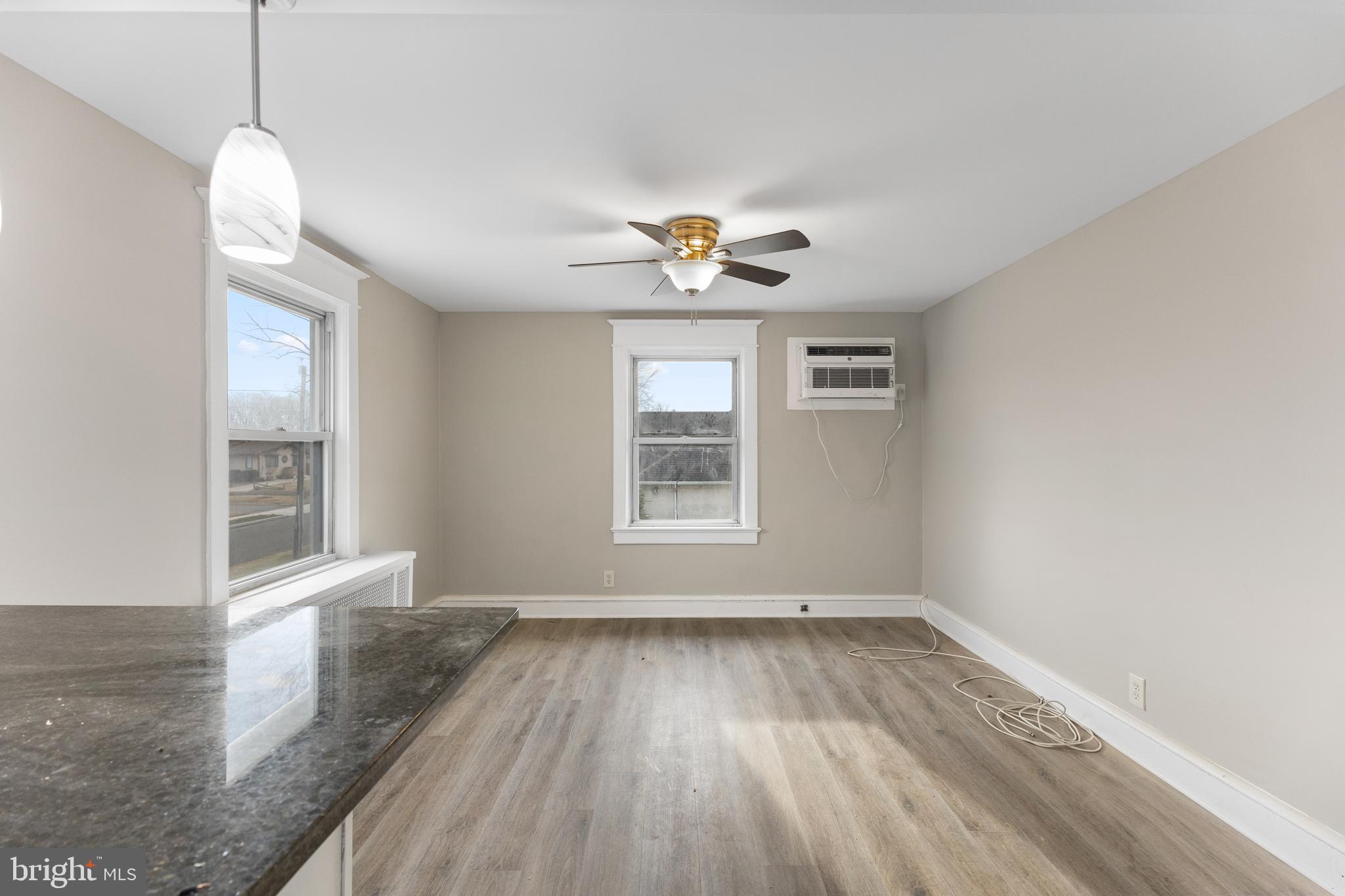 818 Stiles Avenue Maple Shade, NJ 08052 - Photo 5 of 11 an empty room with wooden floor chandelier fan and windows