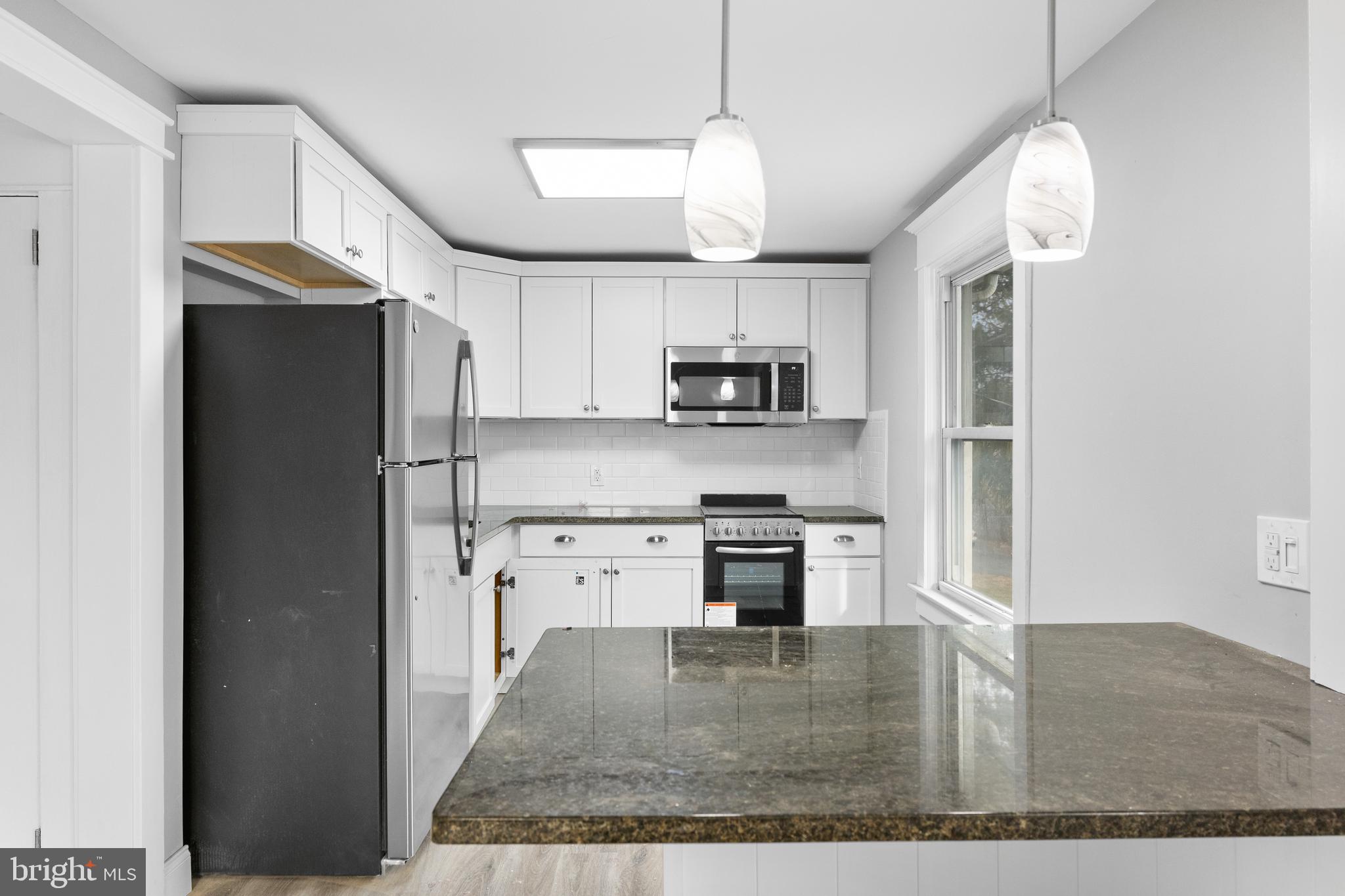 818 Stiles Avenue Maple Shade, NJ 08052 - Photo 6 of 11 a kitchen with kitchen island a counter space a sink appliances and cabinets