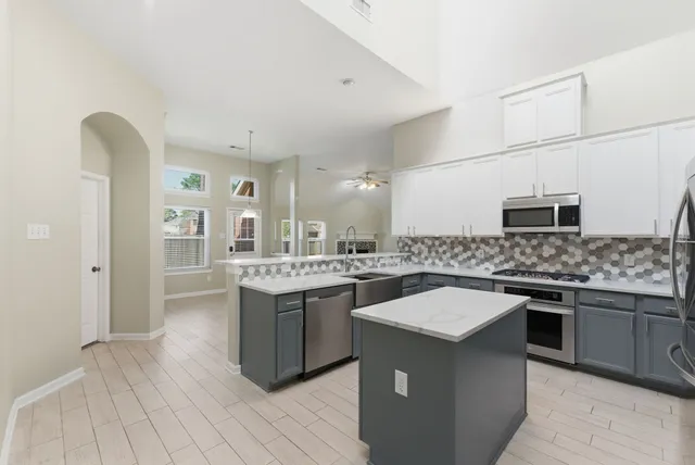 a kitchen with stainless steel appliances granite countertop a sink and stove top oven