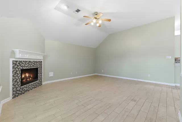 a view of an empty room with a fireplace and a window
