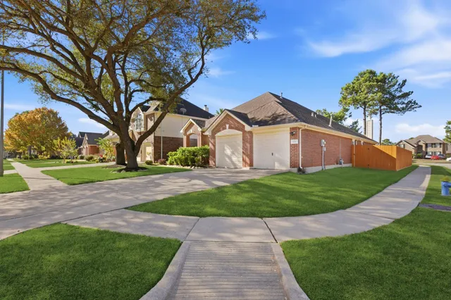 a front view of a house with a garden and tree