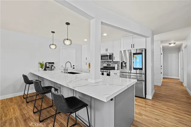 a kitchen with stainless steel appliances a table and chairs in it