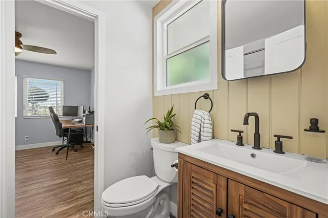 a bathroom with a granite countertop toilet sink and mirror