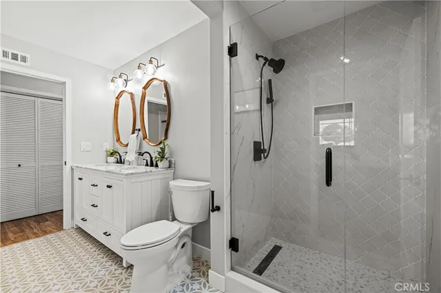 a bathroom with a granite countertop sink mirror and toilet