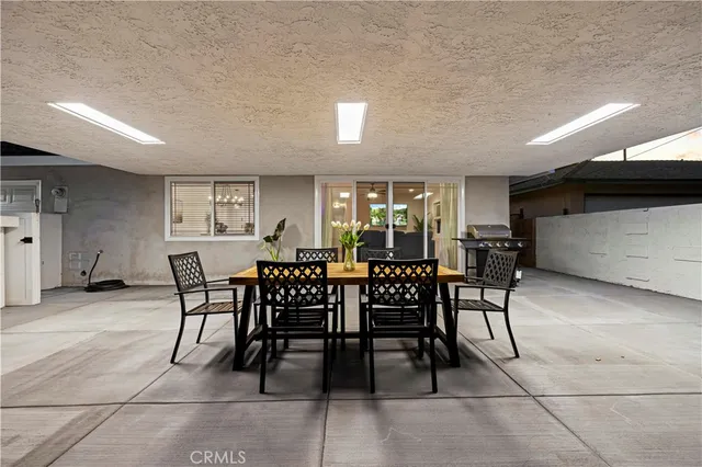 a view of a patio with dining table and chairs with wooden floor