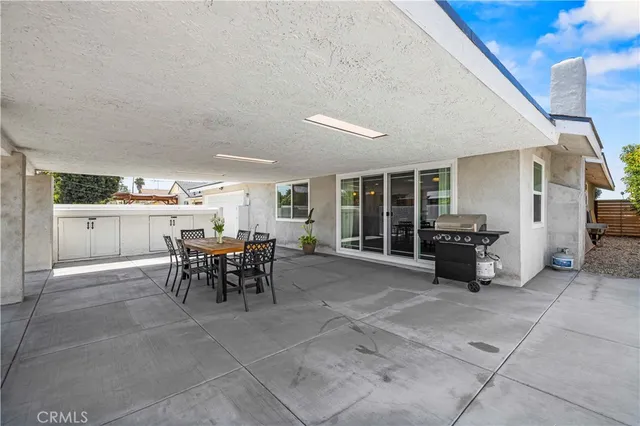 a backyard of a house with table and chairs