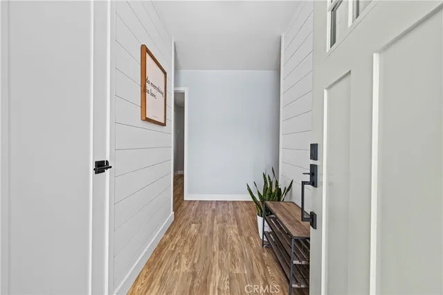 a view of a hallway with wooden floor and a potted plant