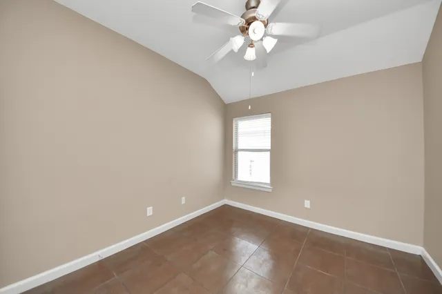 an empty room with windows and ceiling fan