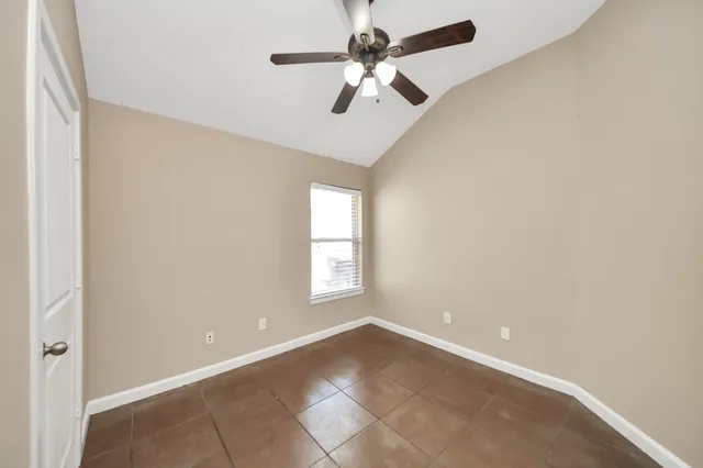 an empty room with a window and a fan
