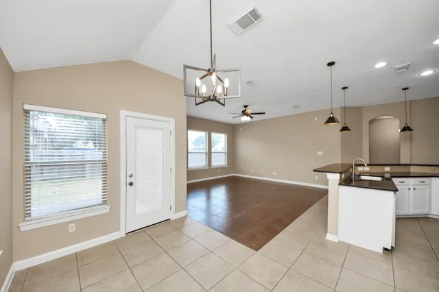 a view of a kitchen with a sink and chandelier