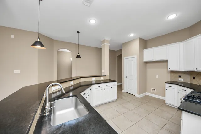 a kitchen with a sink a stove a refrigerator and cabinets