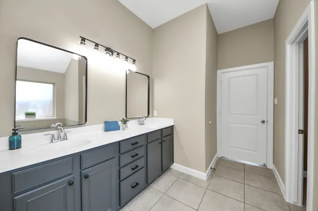 a spacious bathroom with a double vanity sink and a mirror