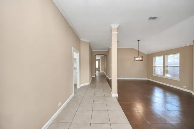 a view of a hallway with wooden floor and a living room