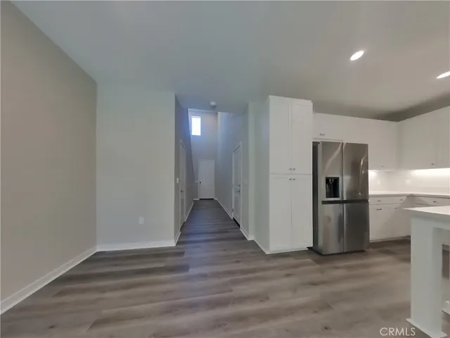 a view of a kitchen with a sink refrigerator and wooden floor