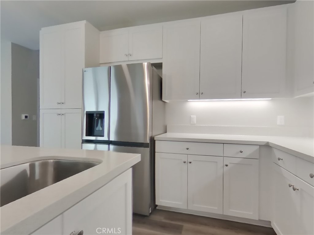 28201 Cookhouse Lane Menifee, CA 92584 - Photo 4 of 32 a kitchen with stainless steel appliances white cabinets and a sink