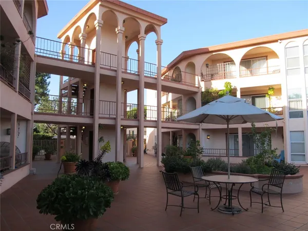 a patio with a table and chairs under an umbrella