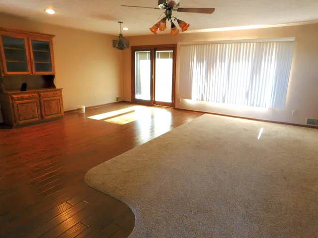 a large kitchen with stainless steel appliances a stove a refrigerator a sink and dishwasher with wooden floor