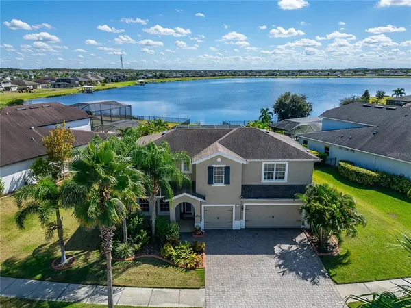 a front view of a house with a yard and lake view