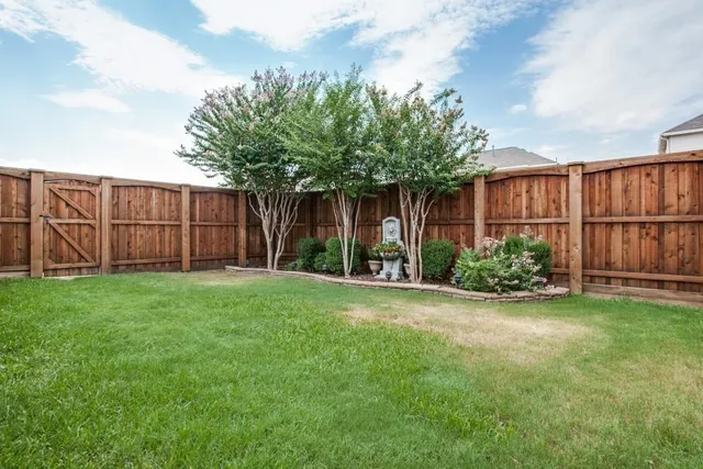 a view of a backyard with potted plants and wooden fence