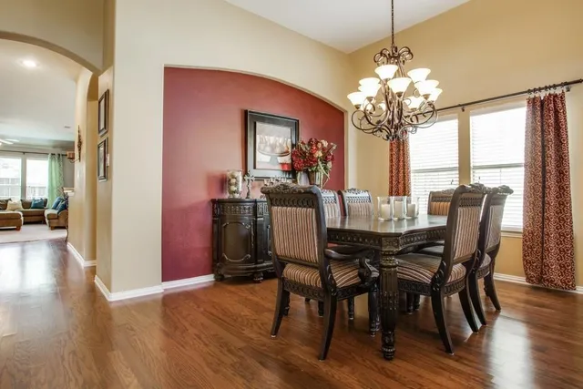 a view of a dining room with furniture a chandelier and wooden floor