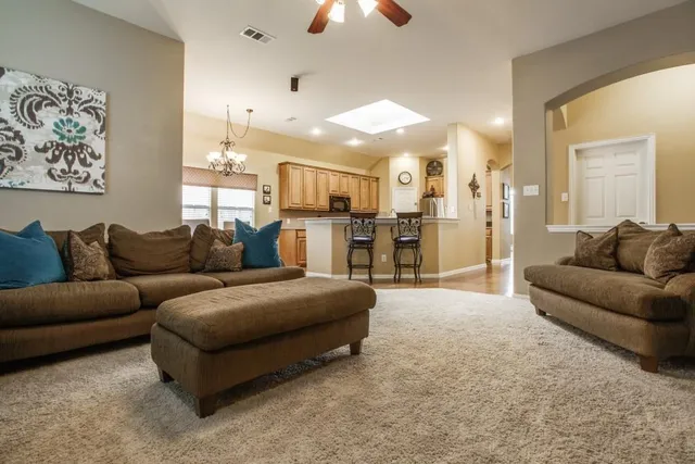 a living room with furniture and a chandelier