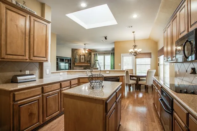 a kitchen with stainless steel appliances granite countertop a sink a stove and a refrigerator