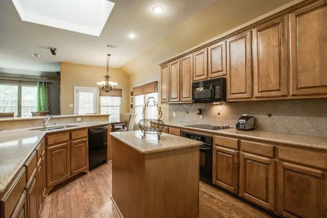 a kitchen with stainless steel appliances granite countertop a sink stove microwave and cabinets