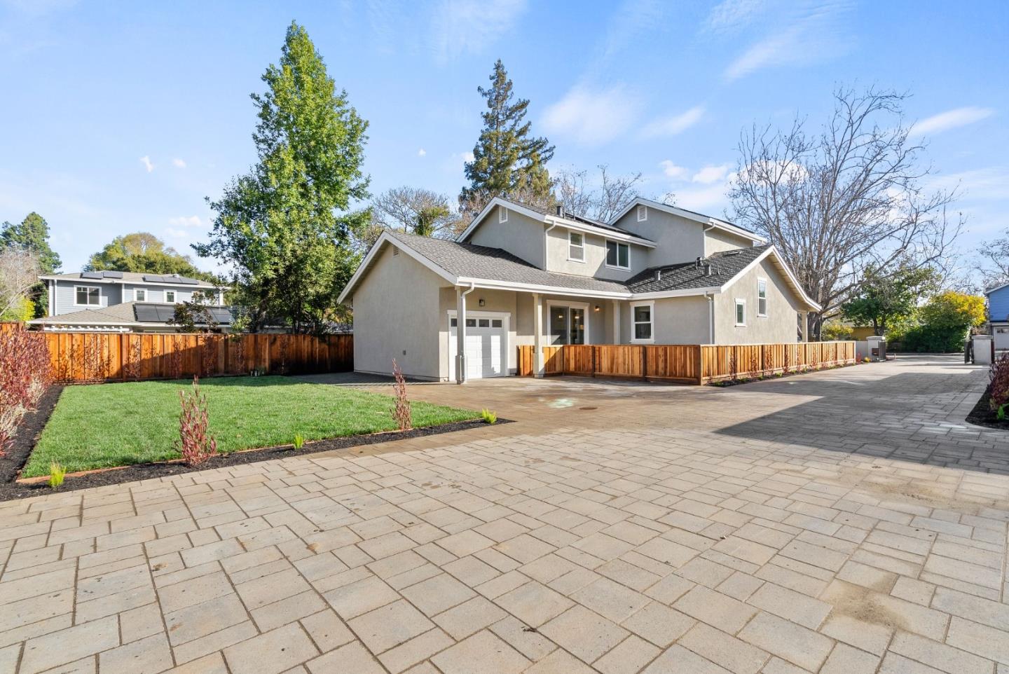 a view of a white house with a big yard and large trees