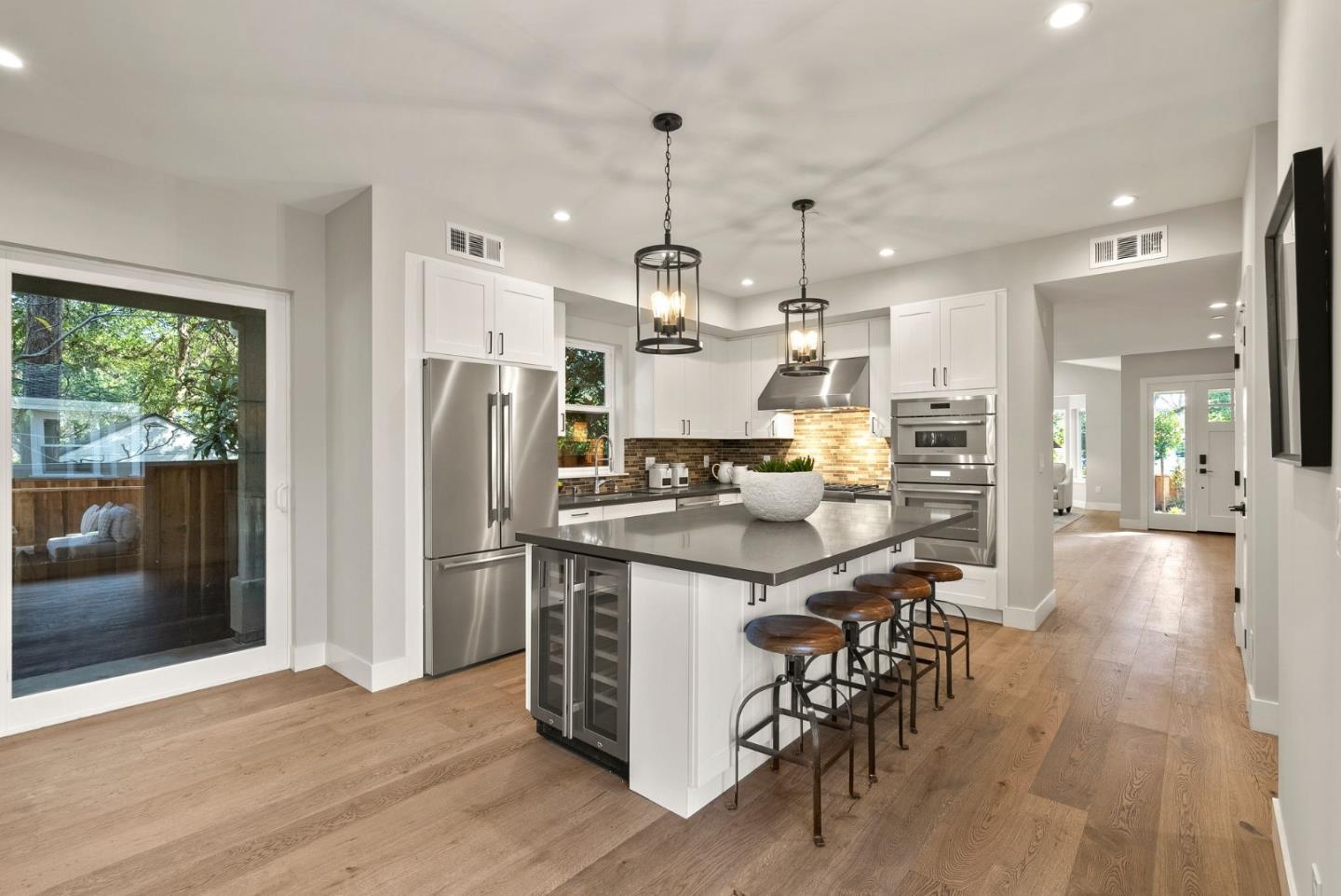 275 Willow Road Menlo Park, CA 94025 - Photo 13 of 40 a kitchen with stainless steel appliances kitchen island granite countertop a dining table chairs refrigerator and sink